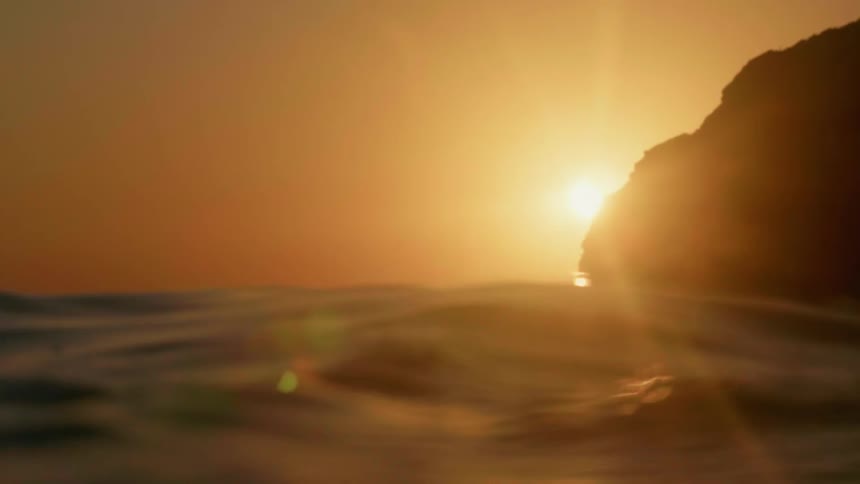 Ocean water is flowing up and down at sunset