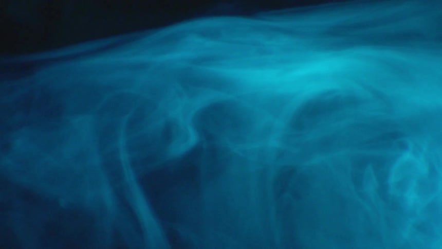 Large clouds of smoke move in the dark room