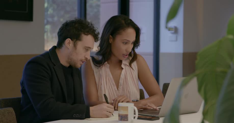 Coworkers look at a laptop
