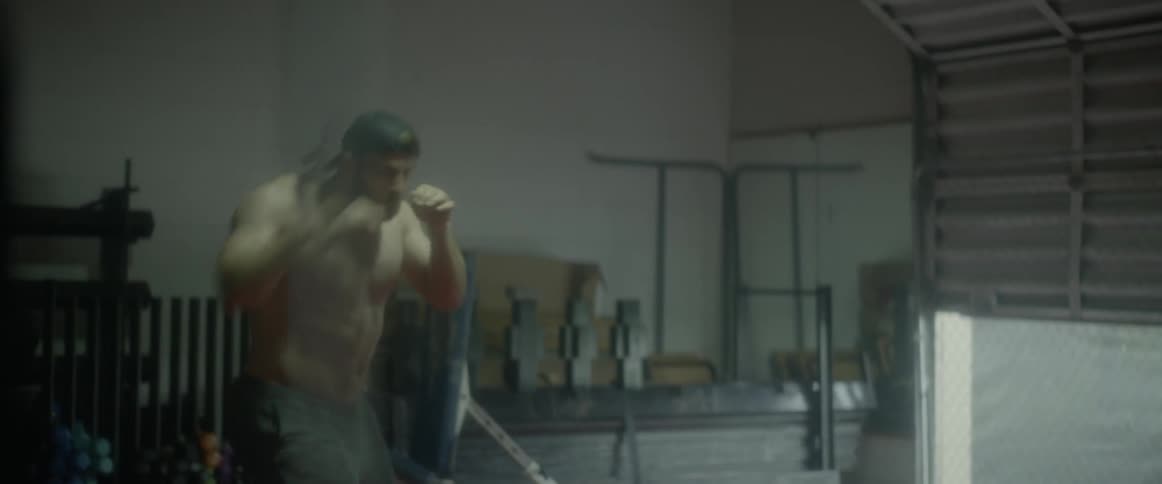 A man is dodging around punching in the gym