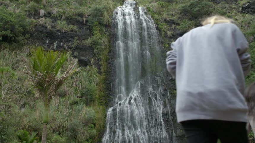 Women are walking toward a waterfall