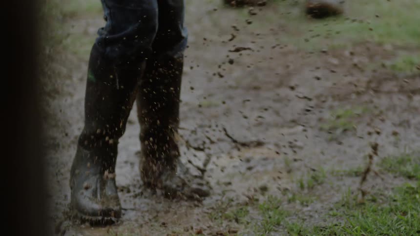 A child splashes in a muddy puddle