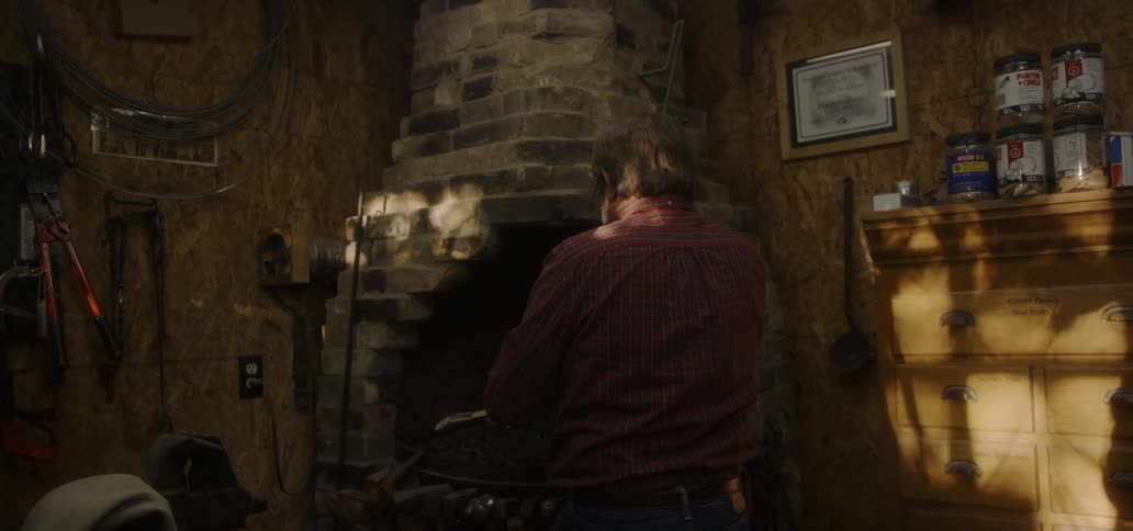 Man stands in front of a brick fireplace