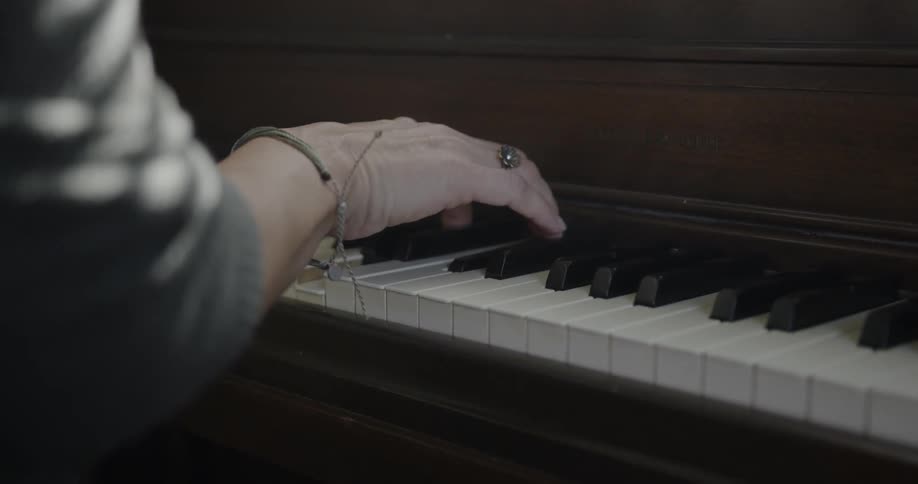 A person is playing the piano with a notebook on top
