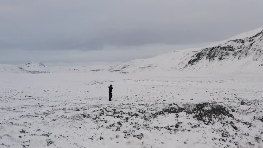 A hiker walks in snowy mountains