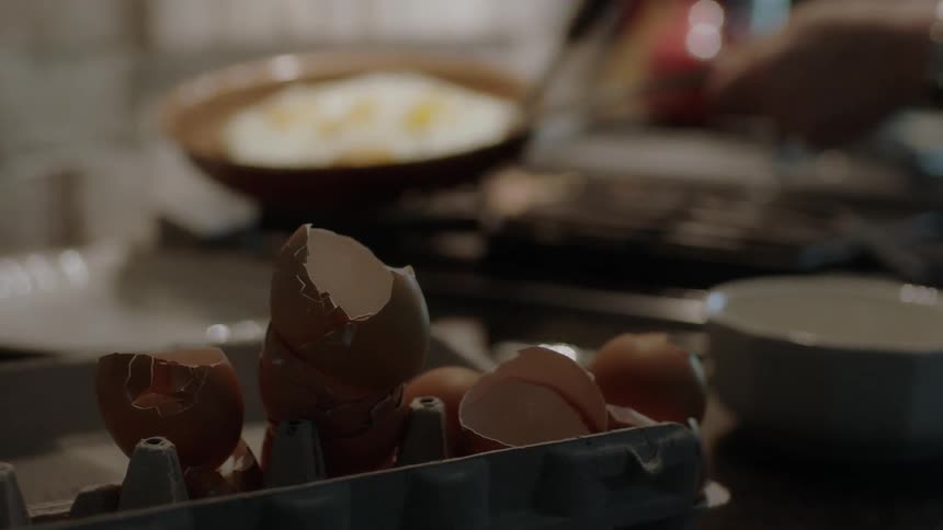 A person cooks eggs on a stove