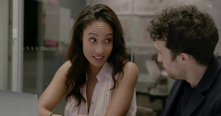 A man and woman sit and converse at a table