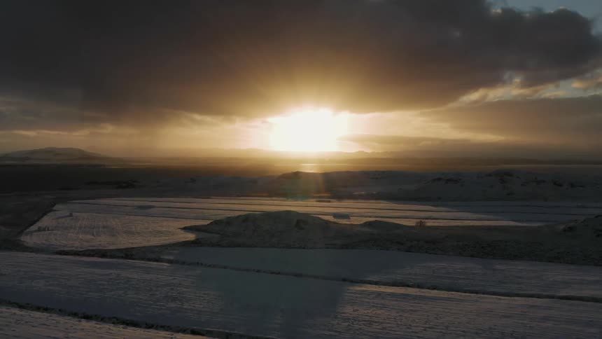 The sun is rising on the coastal horizon of a snow-covered community