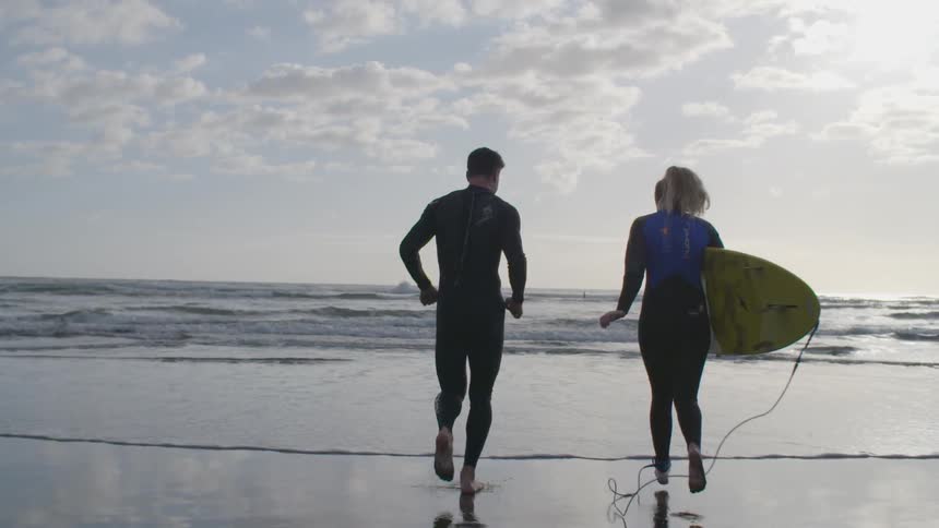 A couple is preparing to surf