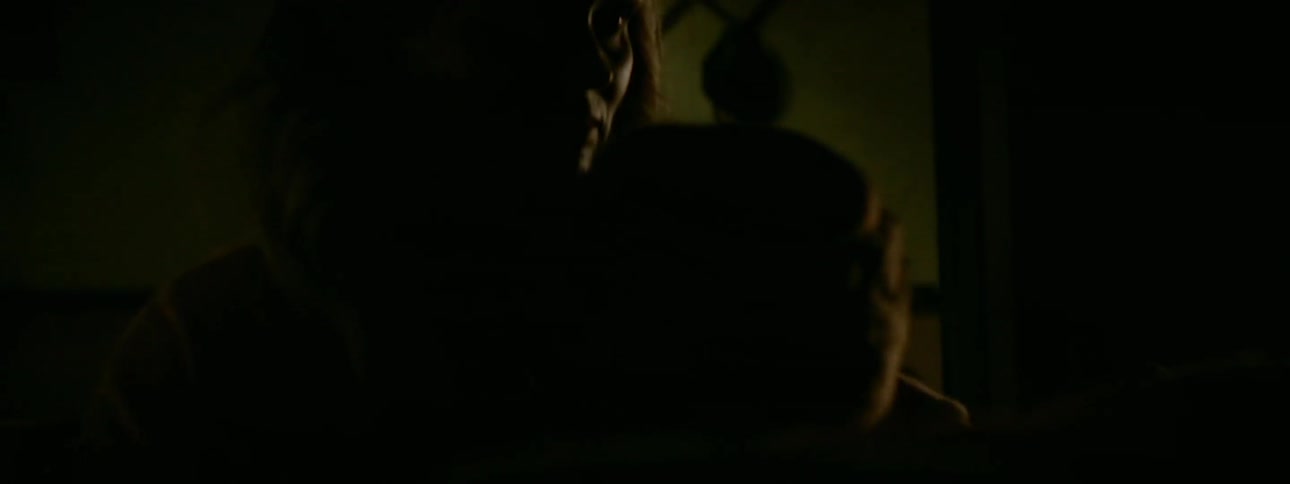 A man and woman kiss in the dark