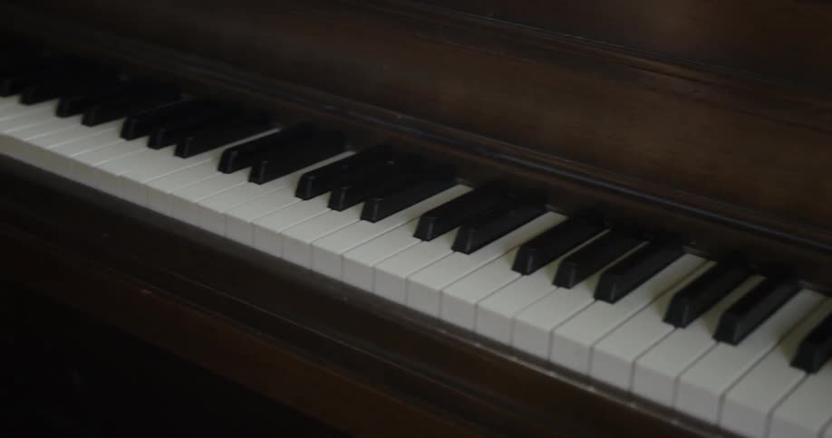 Person pulls out a piano bench and sits down