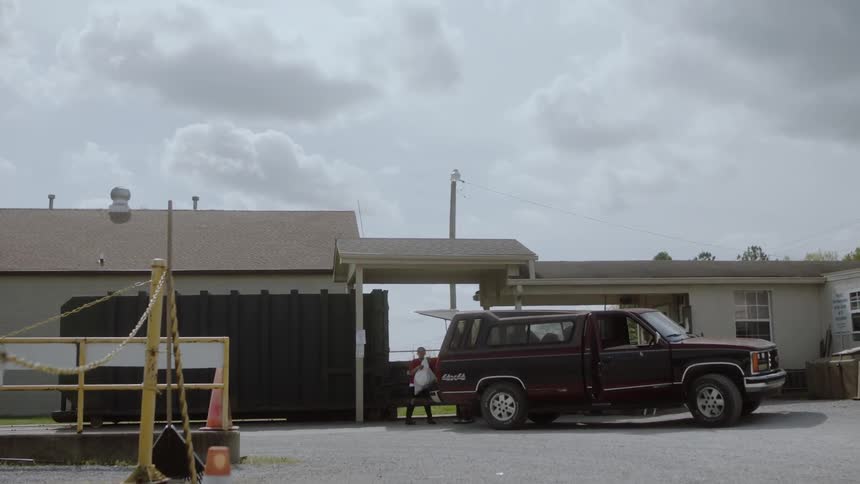 A boy loads a bag into a truck bed