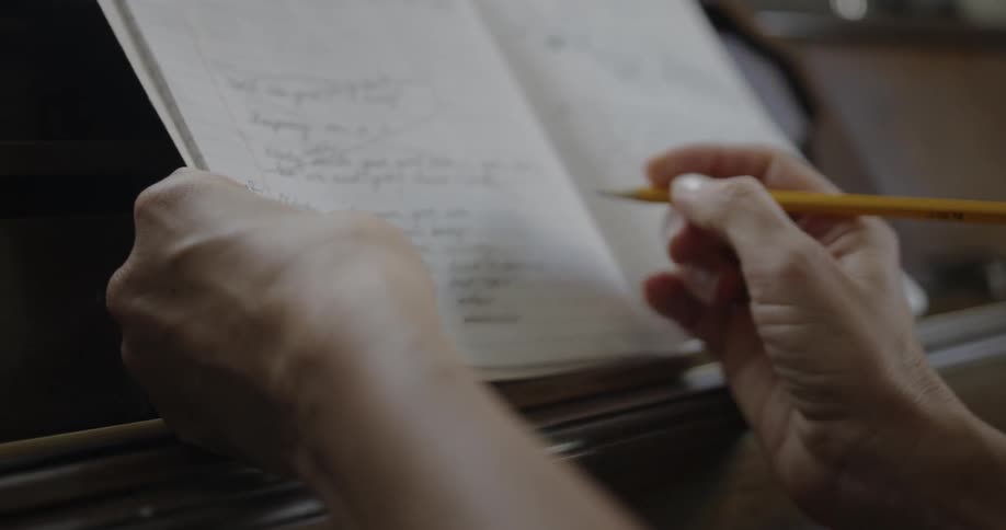 A person is writing in a notebook