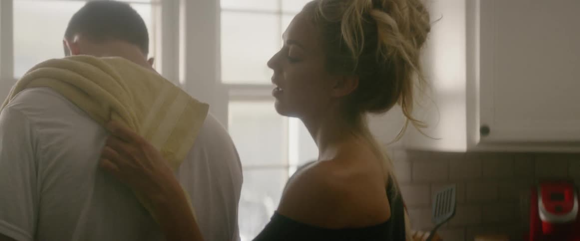 A woman hugs a man in a kitchen