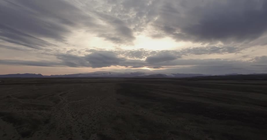 Tracks cut across the desert at sunset