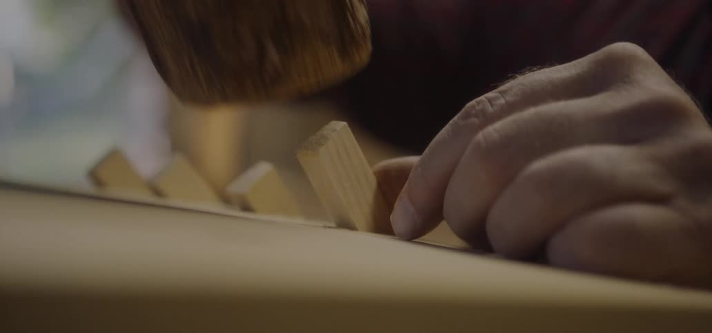 Carpenter hammers a piece of wood