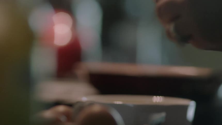 A person is opening eggs into a bowl