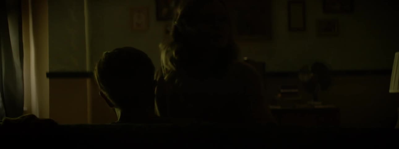 A woman kisses a man while sitting on his lap then moves to the side