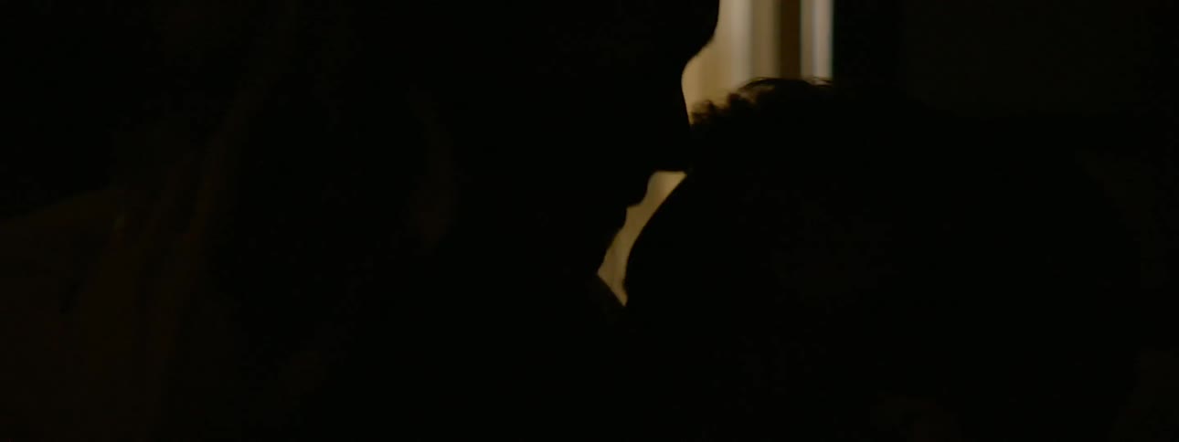 Two people kiss in the dark