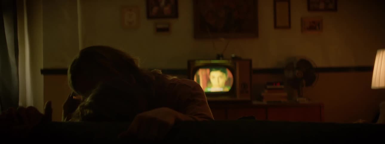A man and woman kiss on a couch