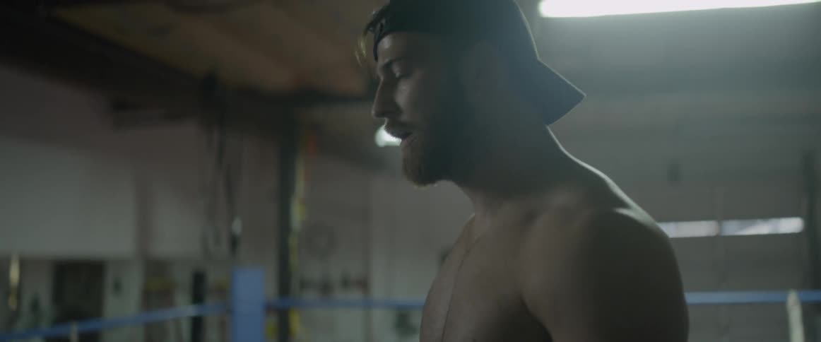 A boxer breathes heavily in a boxing ring