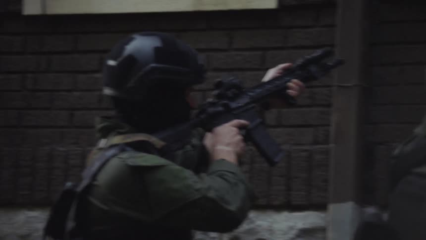 A swat team storms a house with guns drawn