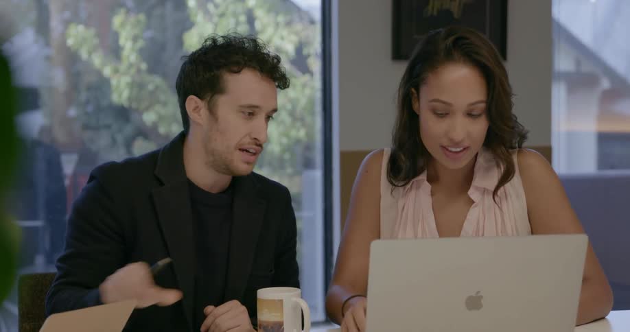 Coworkers look at a laptop