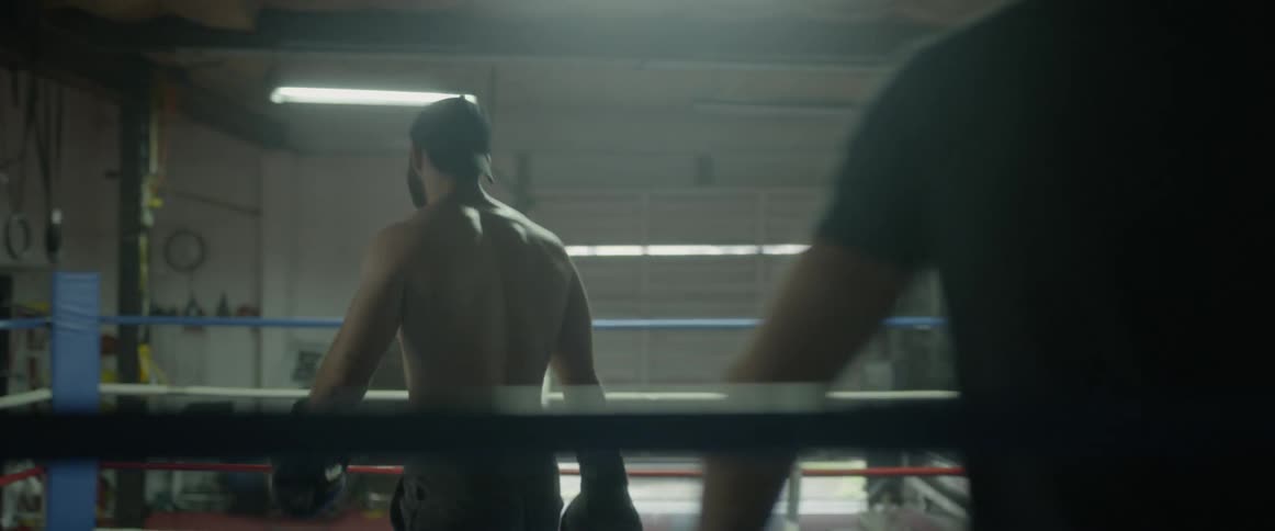 Men train and spar in a boxing ring