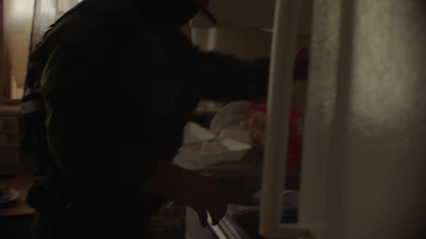 A police officer is dumping food in the sink