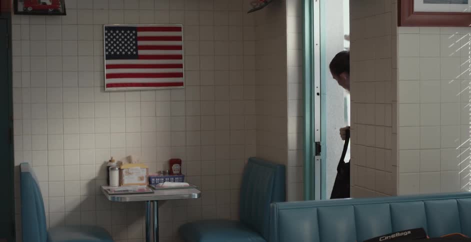A woman exits the restaurant back room and walks out