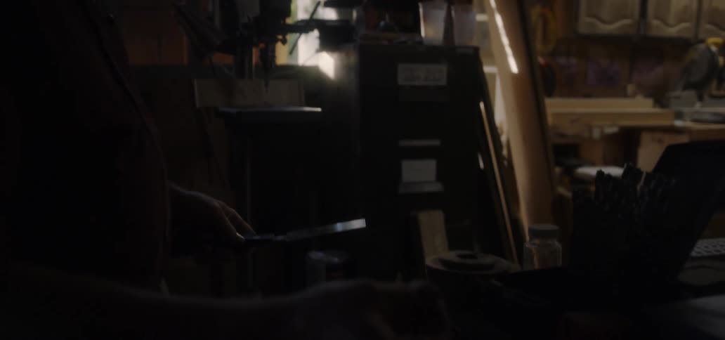 A man is using tools in the garage