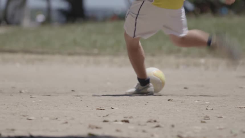 A man runs up and kicks the soccer ball