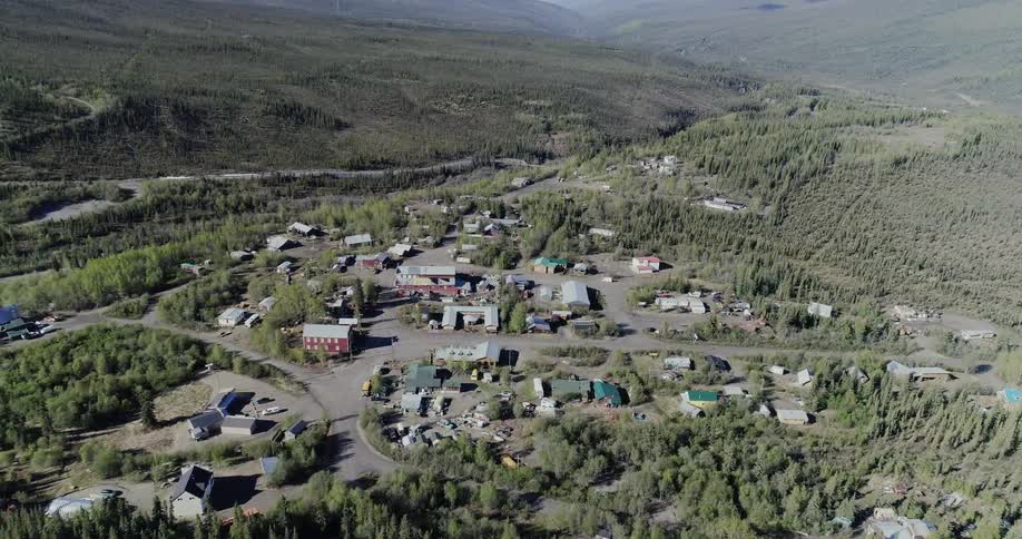 Buildings in small town surrounded by forest of trees
