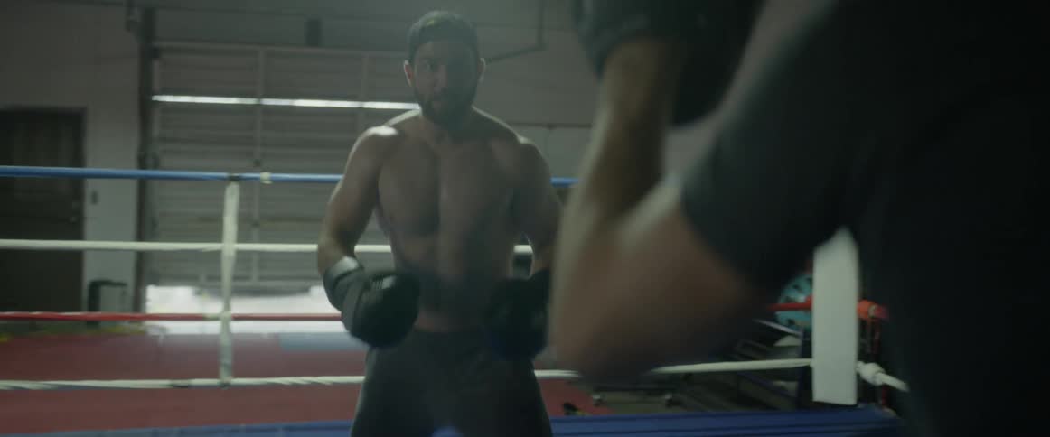 Two fighters are squaring off in a boxing ring inside in daylight