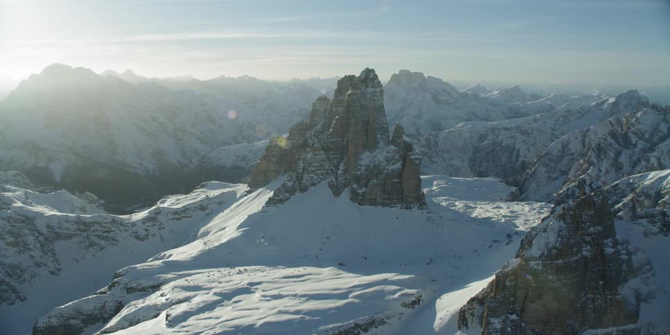 The sun shines over snowy mountains
