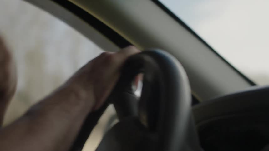 A man turns the car steering wheel