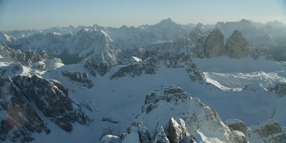 Sun shines down on a snow covered mountain range