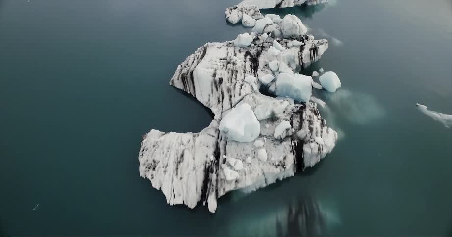 Icebergs are floating in the ocean in daylight