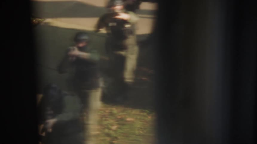 A swat team approaches a building