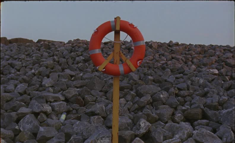 A life preserver hangs on a wood pole