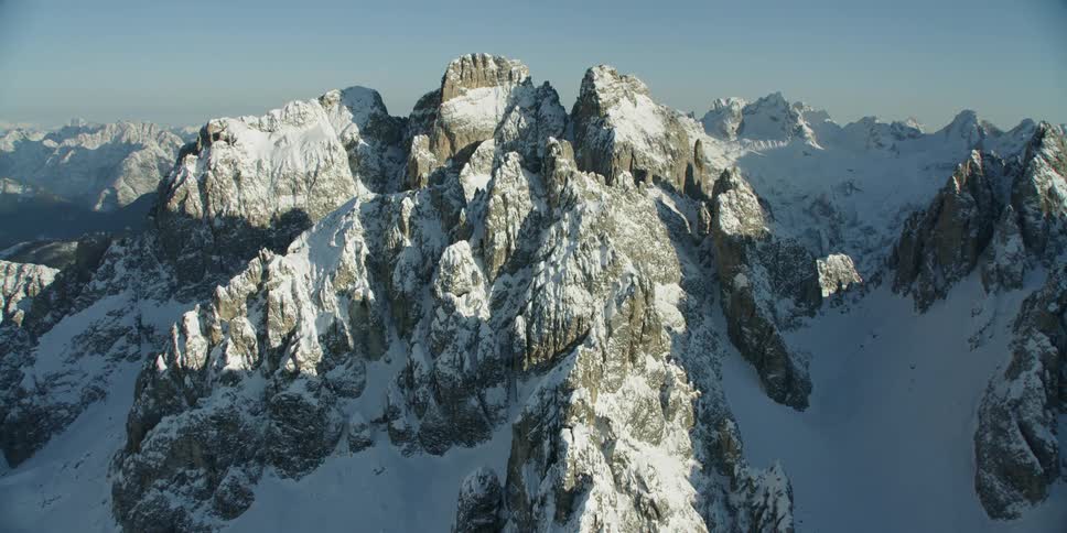 Snow covered mountains sit under a blue sky