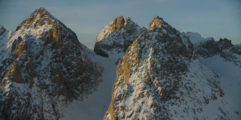 Sun shines over snow capped mountains