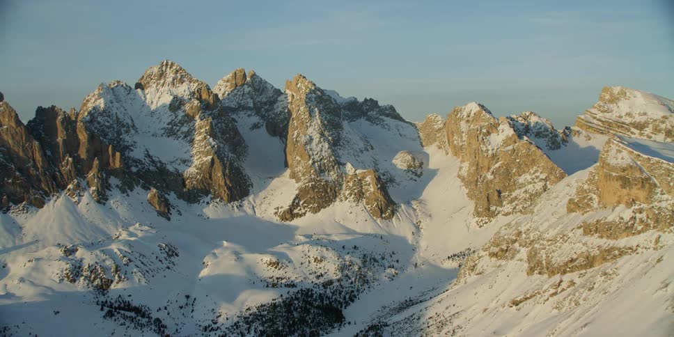 The sun is shining high above the vast mountain range