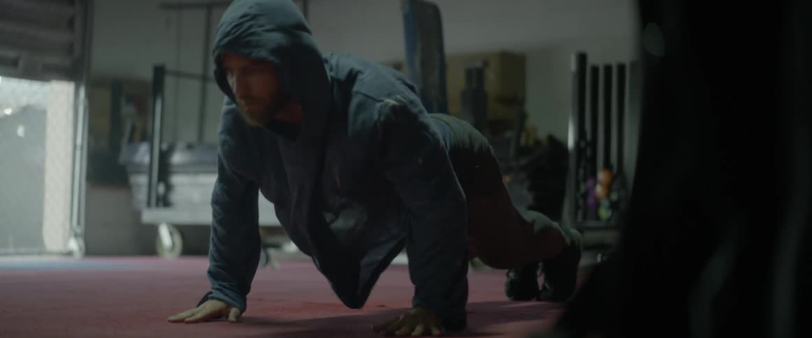 A man does exercises wearing a hooded shirt