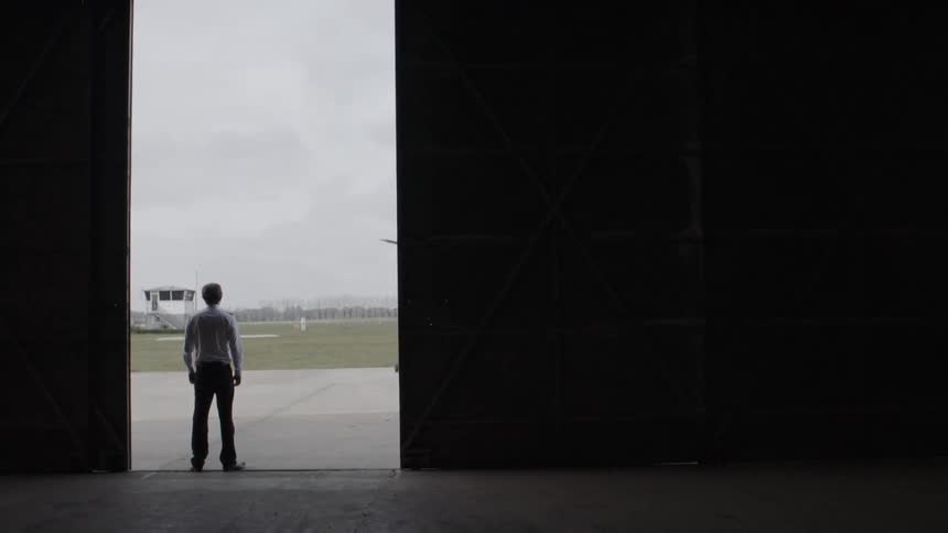A man walks over to the open hangar door