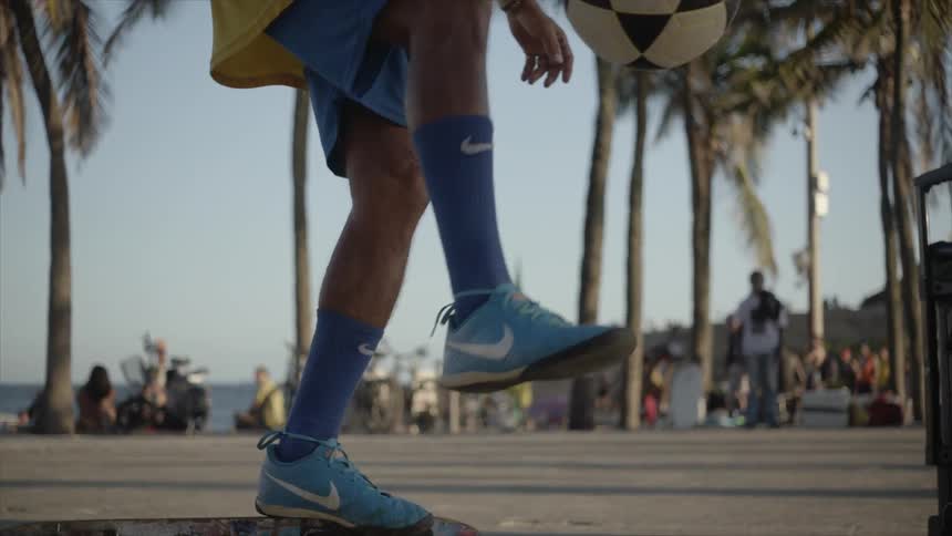 A soccer player in a yellow uniform dribbling a soccer ball on their foot