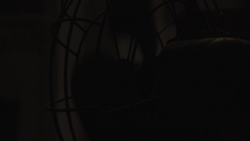 The fan spins in the dark room