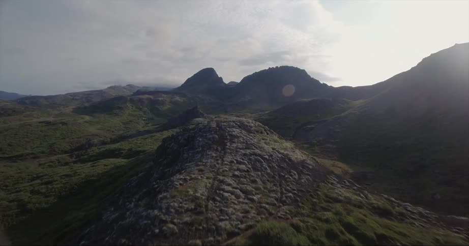 The hills are green and leading to heavy clouds ahead
