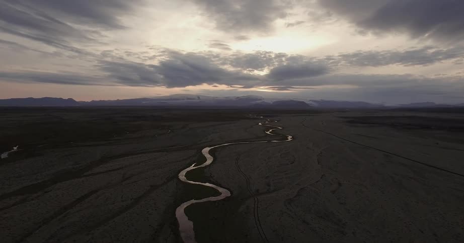 A river flows through a rural landscape at sunset