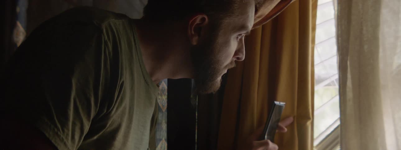 A man looks out the window worried